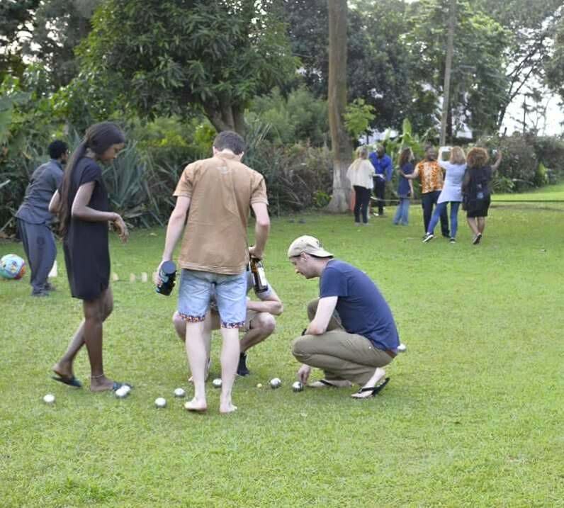 Groupe d'amis jouant à la pétanque sur la pelouse en fin de journée