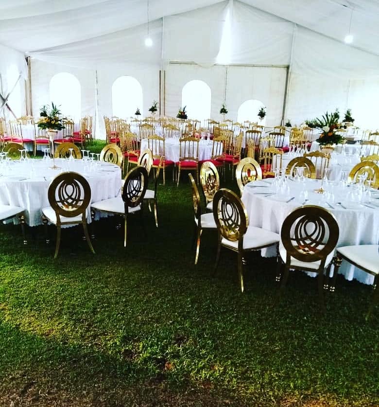 Grande tente de réception avec chaises dorées alignées pour une célébration